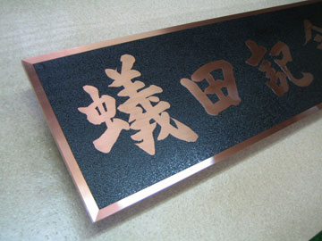 銅製筆文字銘板の左からみた画像